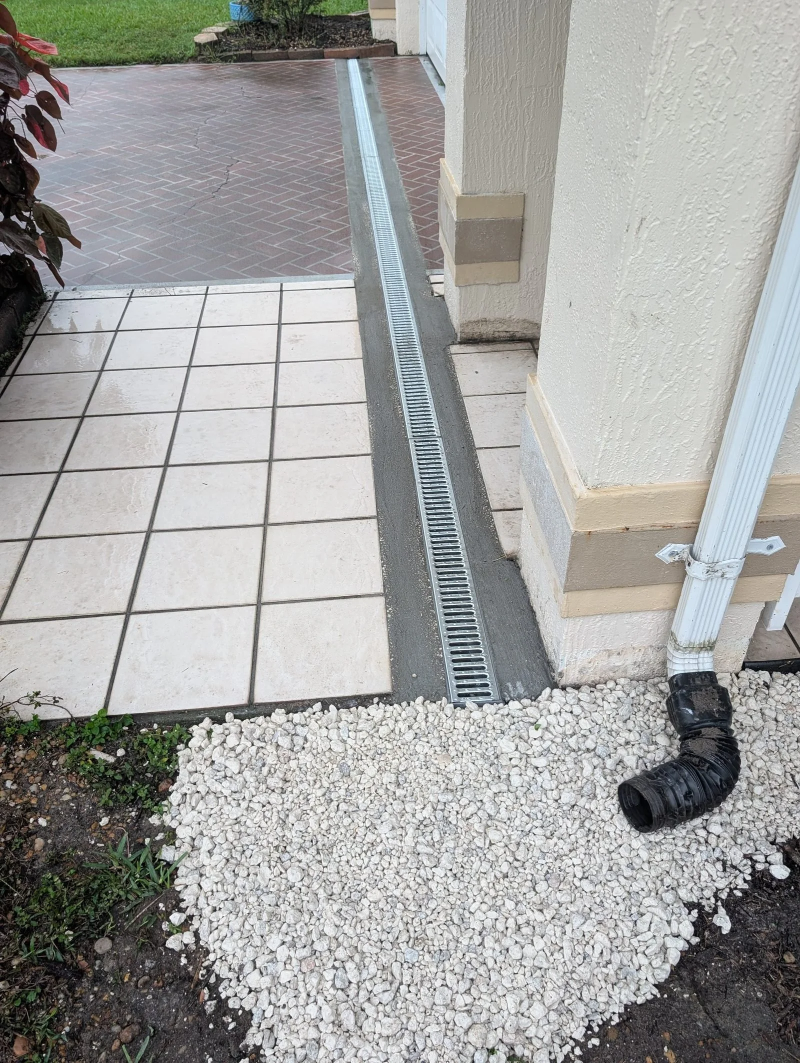 Finished pavers and channel drain along the house after the Polk Services job.