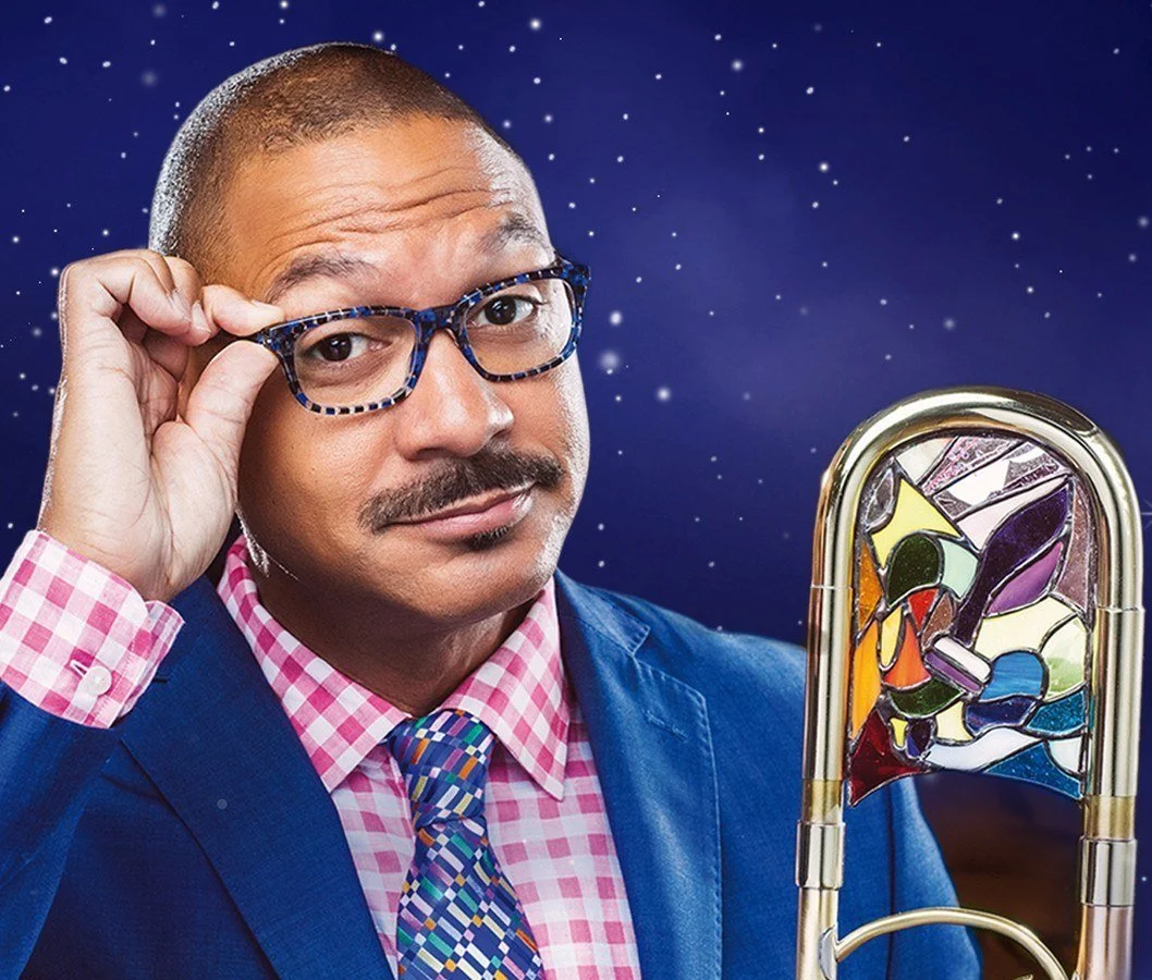 Delfeayo Marsalis holding his glasses, with his stained-glass trombone