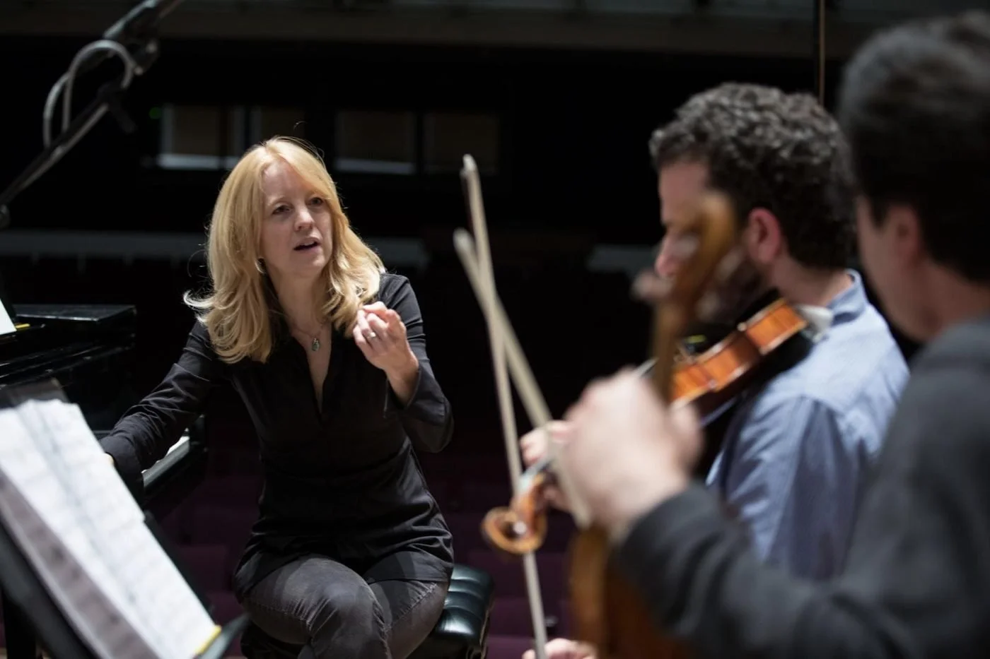 Maria Schneider in rehearsal at the piano, with string players