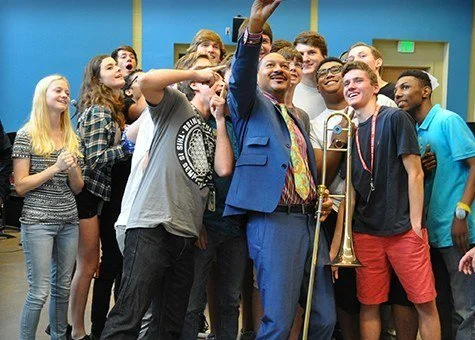 Delfeayo Marsalis working with a student jazz band in a classroom