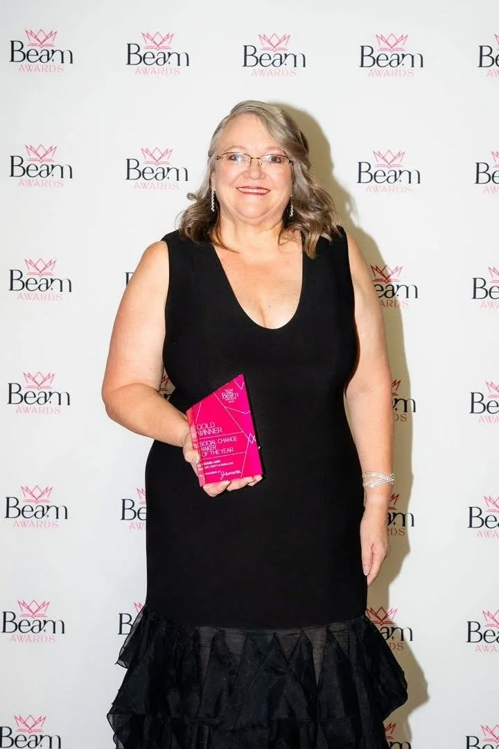 Susan holding her pink Beam Social Change Maker trophy