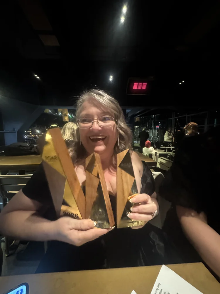 Susan holding her ROAR trophies