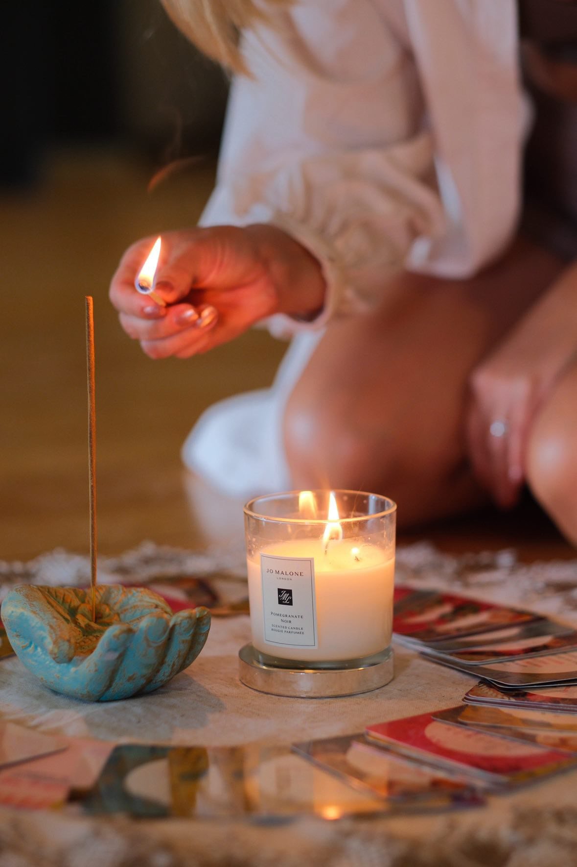 A candle, cards and crystals on a table at the healing salon