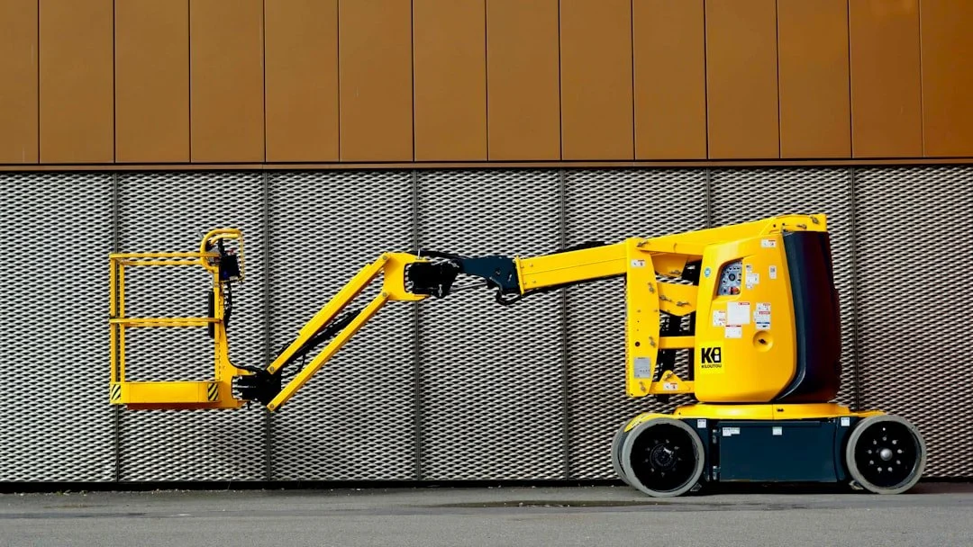 Telescopic and articulating boom lift operating on construction site