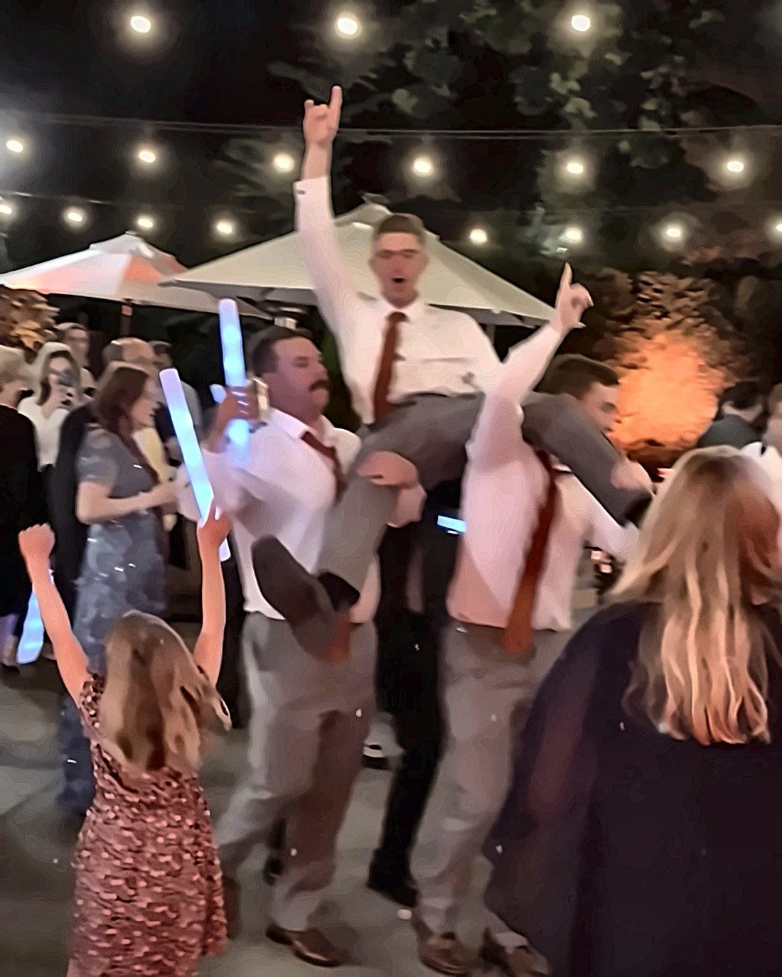 Guests lifting the groom on their shoulders on the dance floor