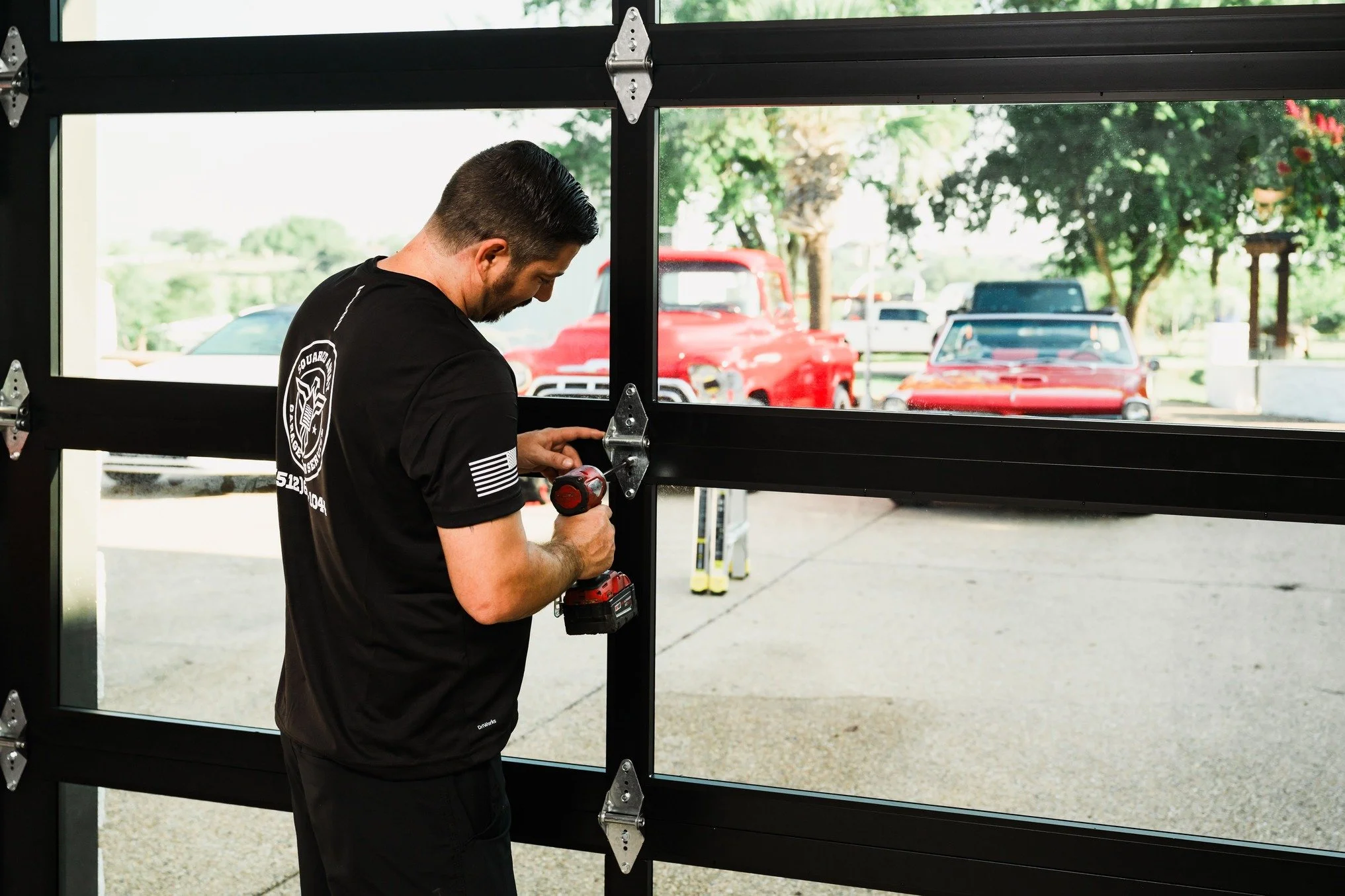 a technician re-anchoring a garage door track to the jamb on a Hutto home in Hutto, TX by Squared Away Garage Door Service