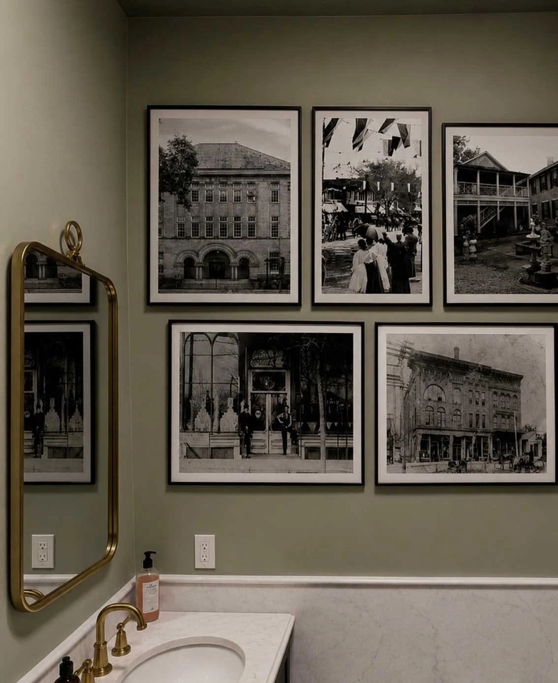 Guest bathroom with brass fixtures and historic photographs