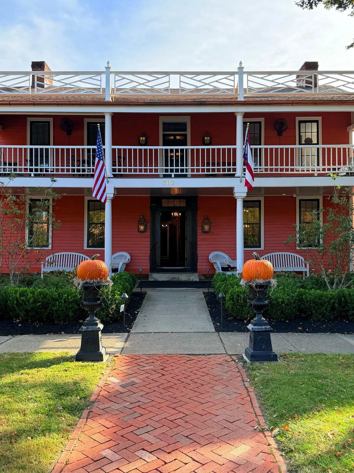 The Buxton Inn’s historic front entrance, with pumpkins flanking the walkway and gas lanterns beside the door.