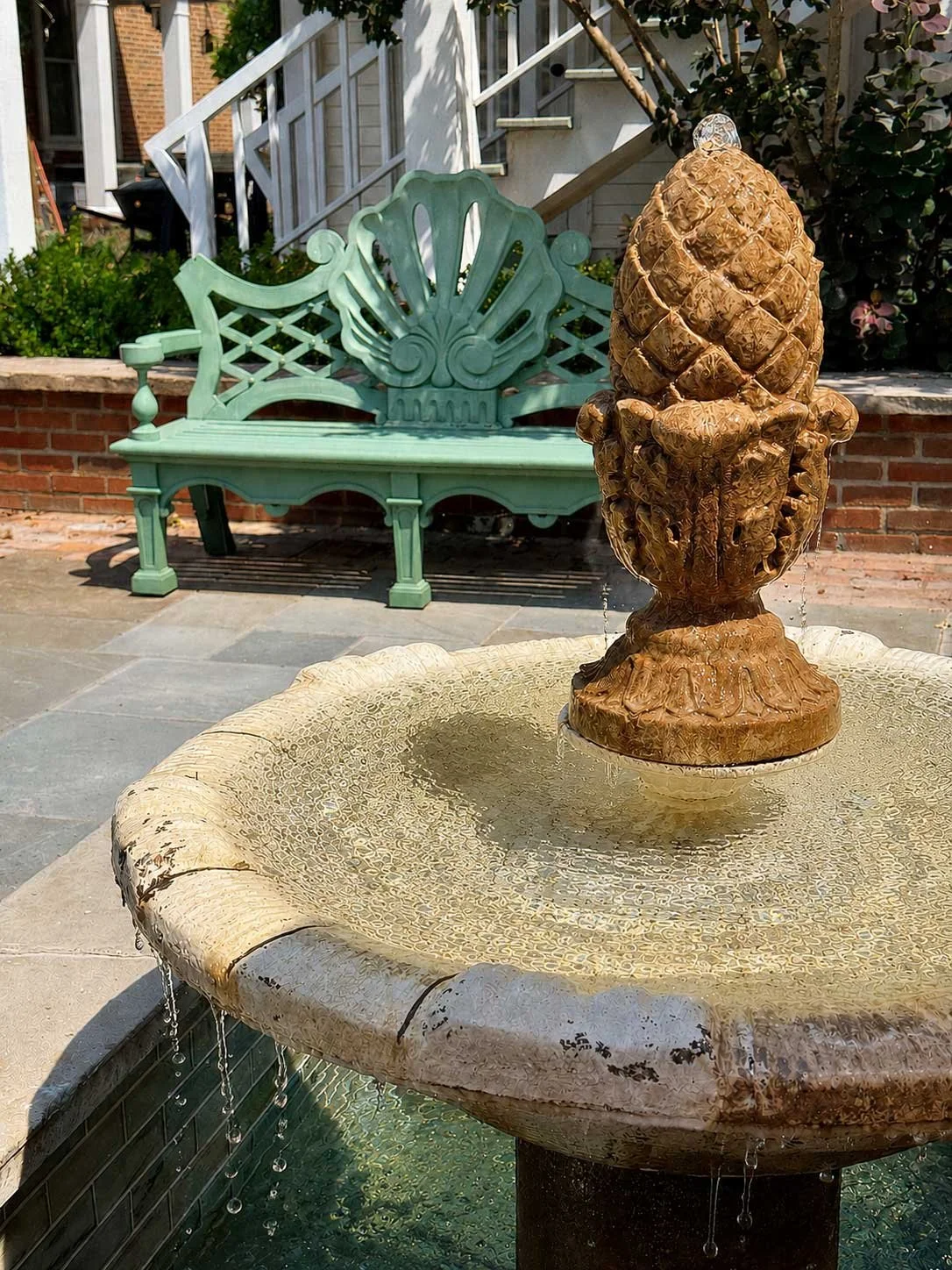 The courtyard fountain and historic green bench at The Buxton Inn in Granville, Ohio