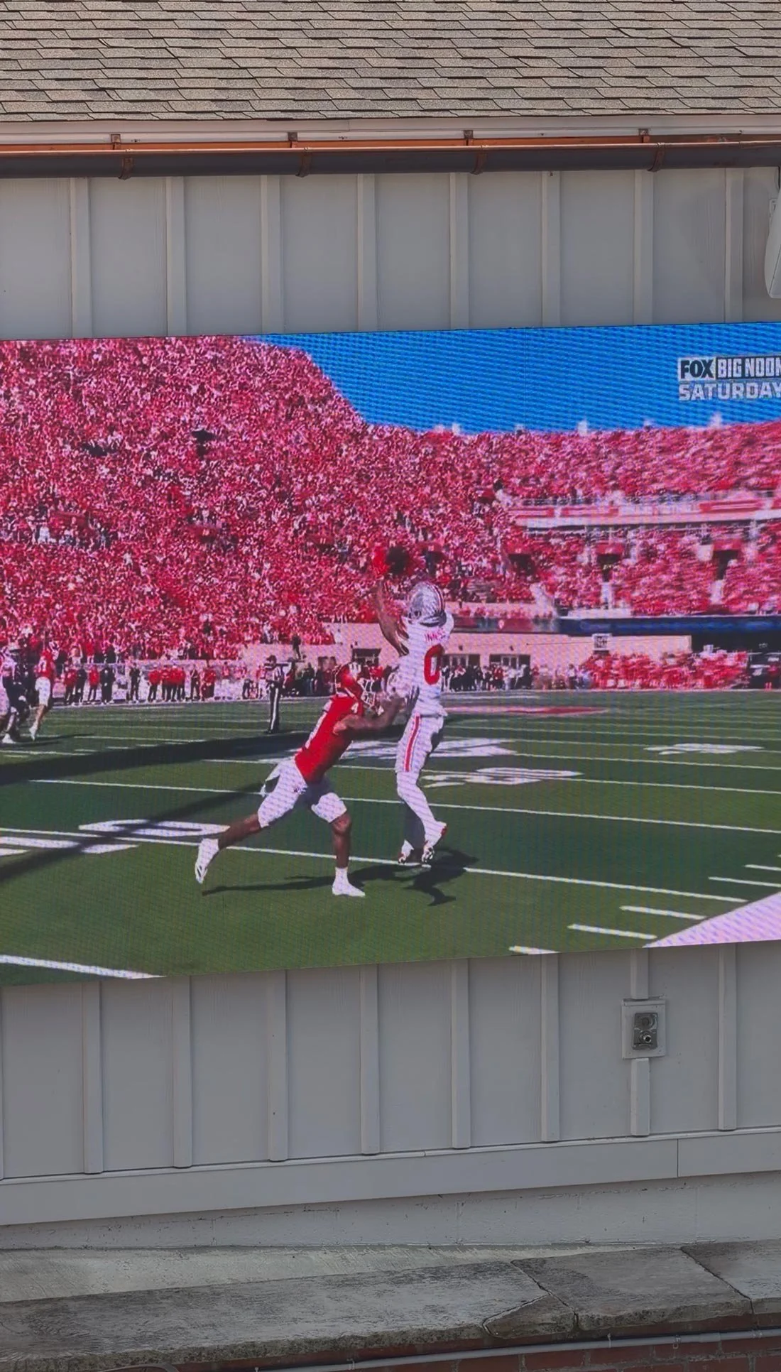 A football catch shown on the large outdoor screen in the Buxton Inn courtyard.