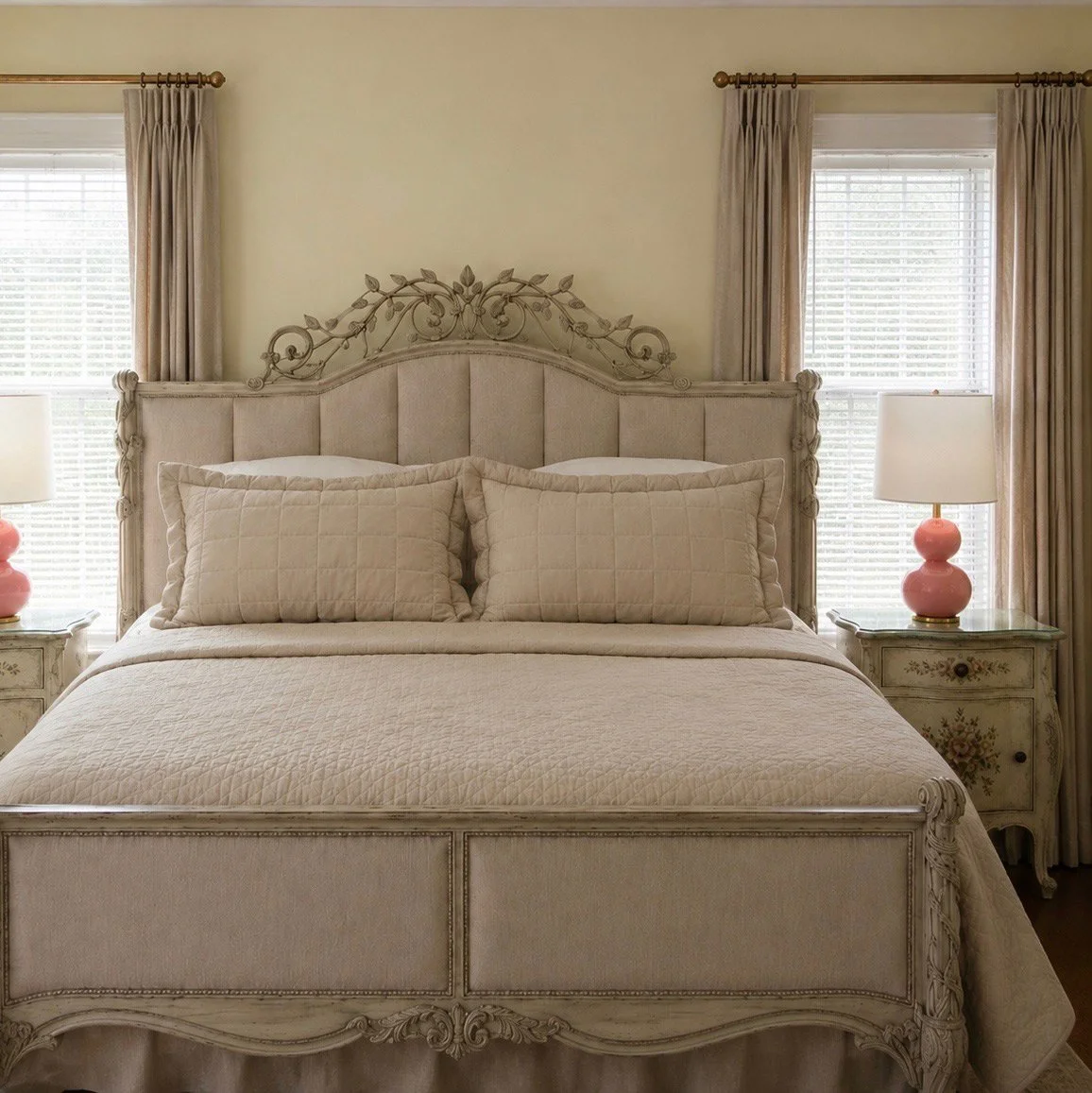 Bright guest room with an upholstered bed and pink lamps
