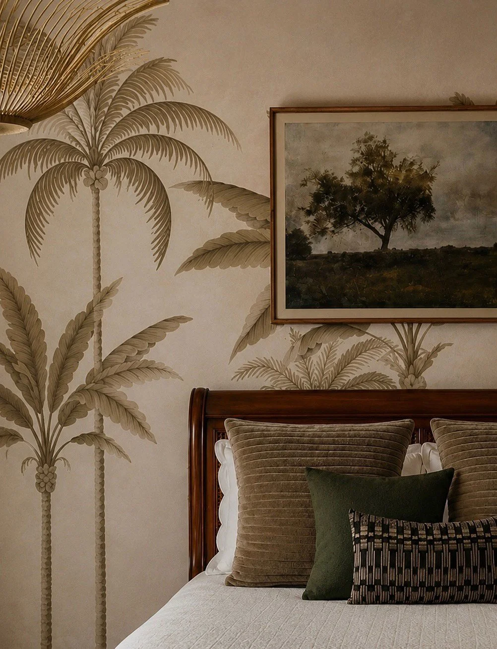 Guest bed framed by palm-tree wallpaper and layered pillows