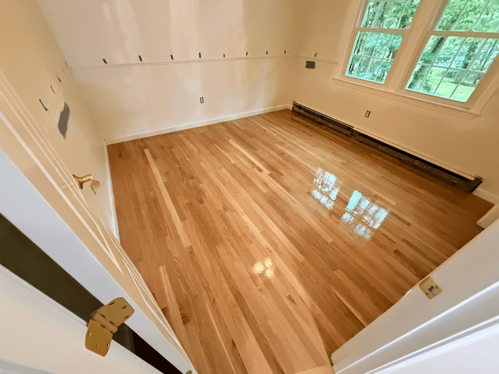 Finish being applied to the Andover white oak floor