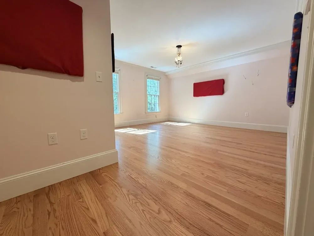 Completed red oak flooring in the Wellesley bedroom with red wall panels