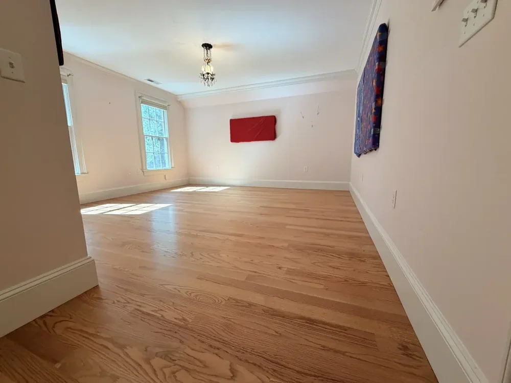 The same Wellesley bedroom after red oak installation, custom staining, and finishing