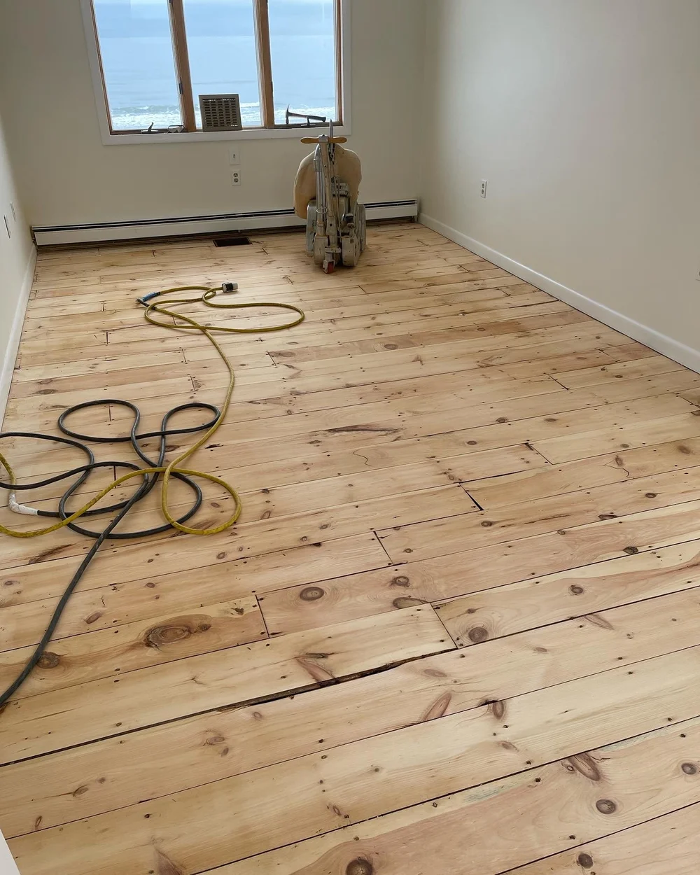 Older wide-plank pine floor freshly sanded