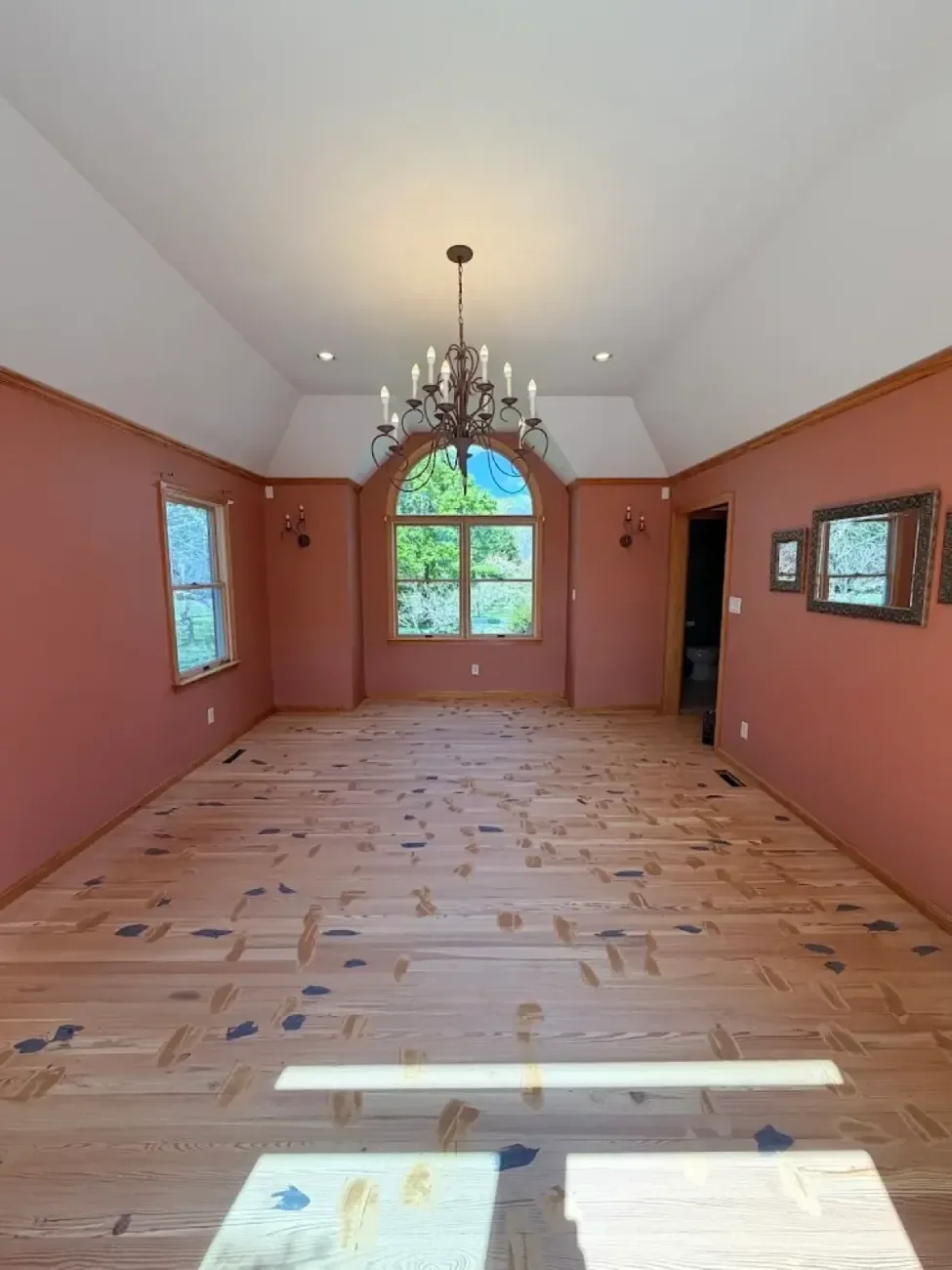 Sanded hardwood floor with wood filler applied between floorboards where appropriate