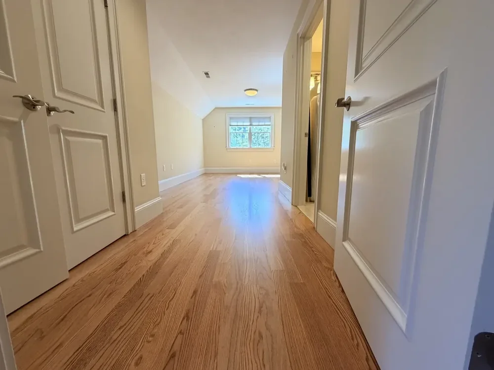 Hallway to the rear bedroom after red oak installation and finishing
