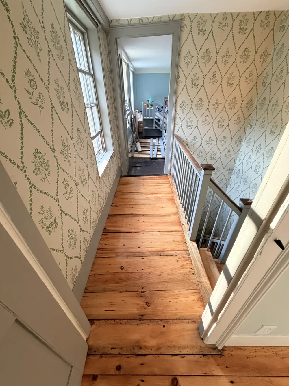 Wallpapered landing toward bedroom after refinishing