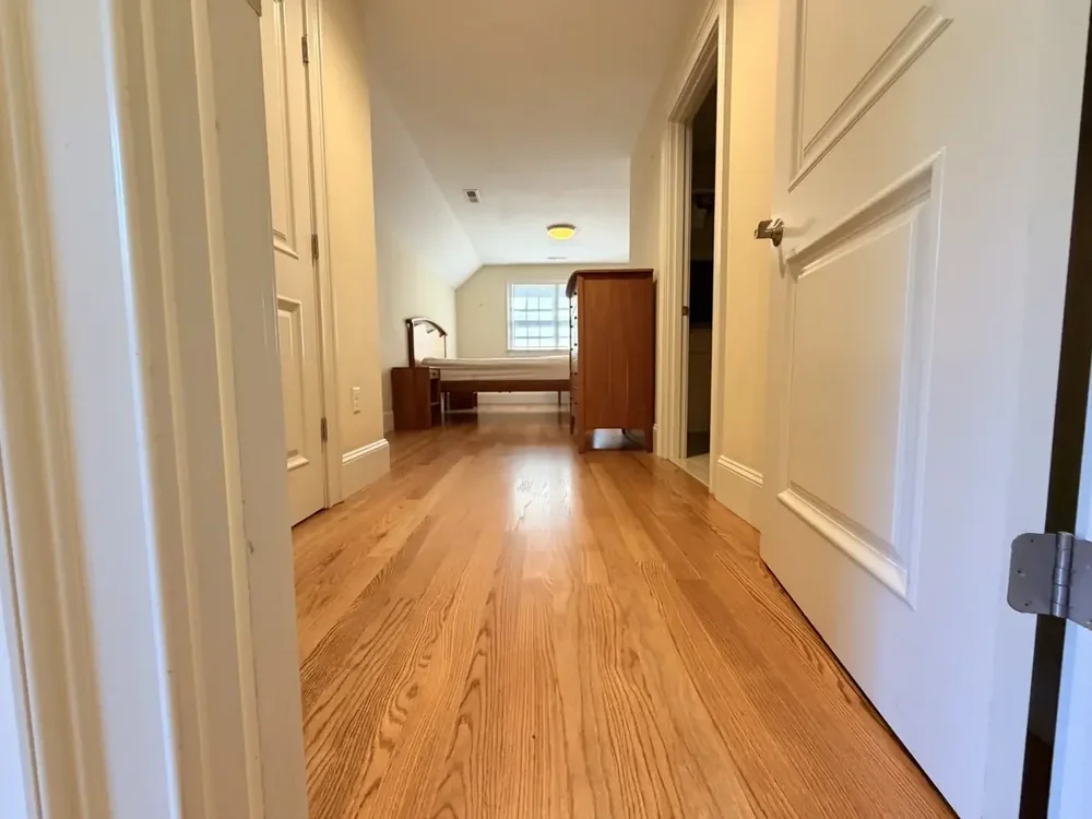 Completed red oak flooring in the Wellesley hallway and rear bedroom with furniture returned