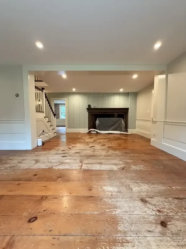Original wide-plank floors in the Weston fireplace room before refinishing