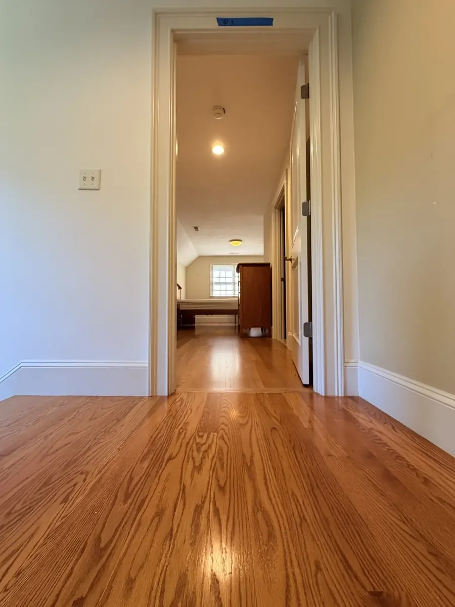Completed red oak flooring in the Wellesley hallway and rear bedroom with furniture returned