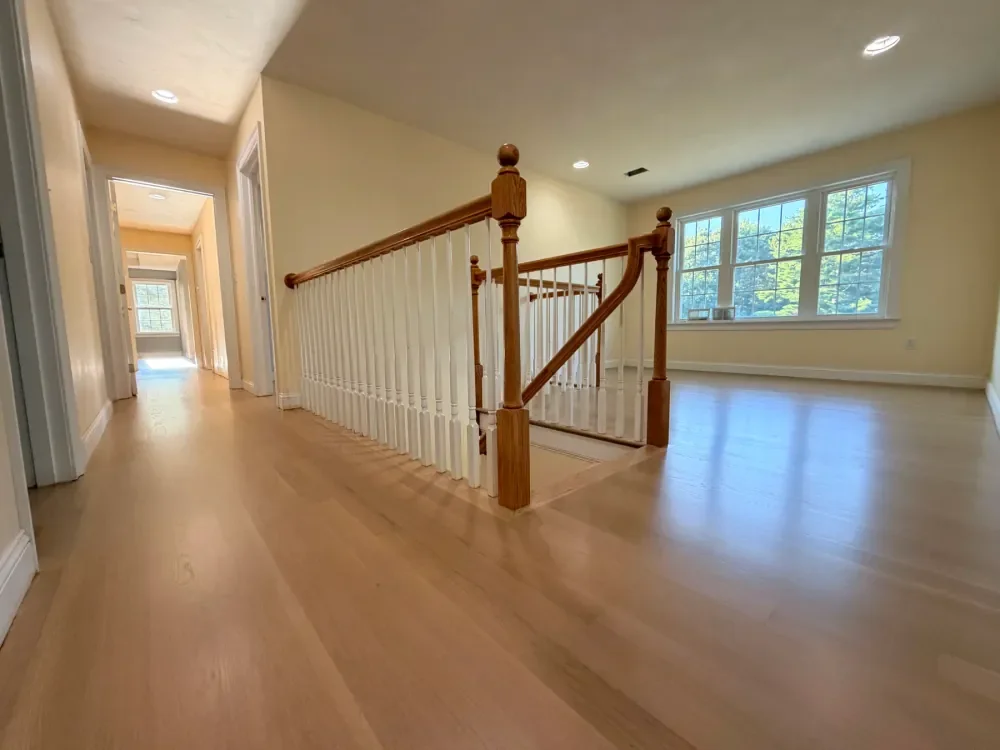 Completed light hardwood installation connecting rooms and a staircase