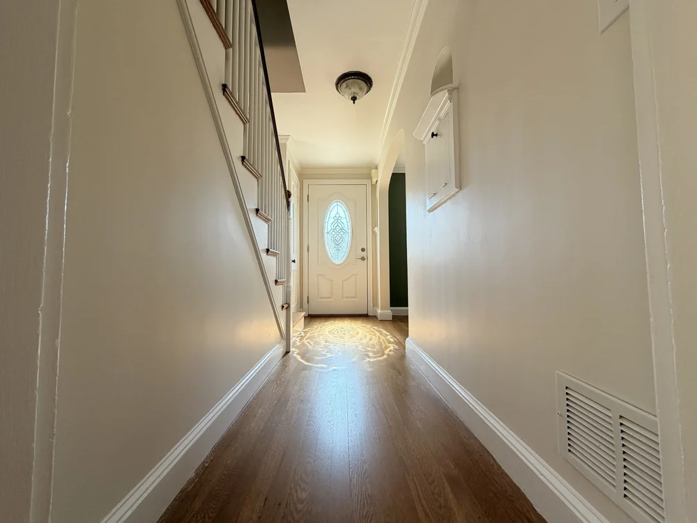 Satin hardwood floor leading toward the front door