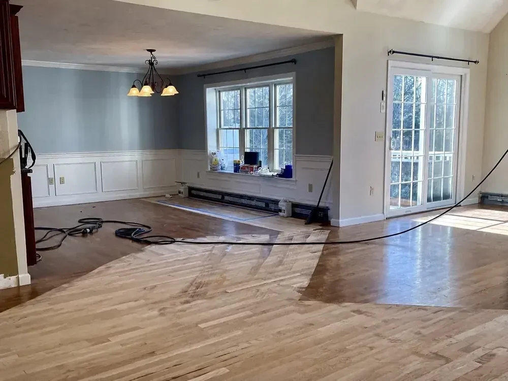 Worn hardwood floor being evaluated before refinishing
