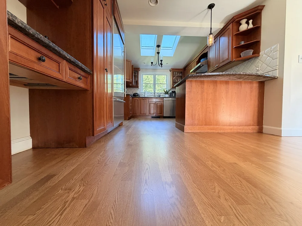 Custom-stained hardwood floor between kitchen cabinets