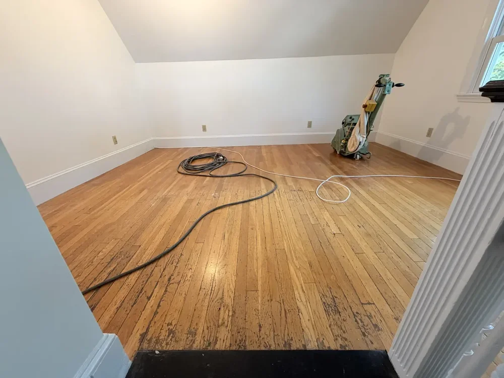Worn hardwood in the Cambridge room before sanding and refinishing