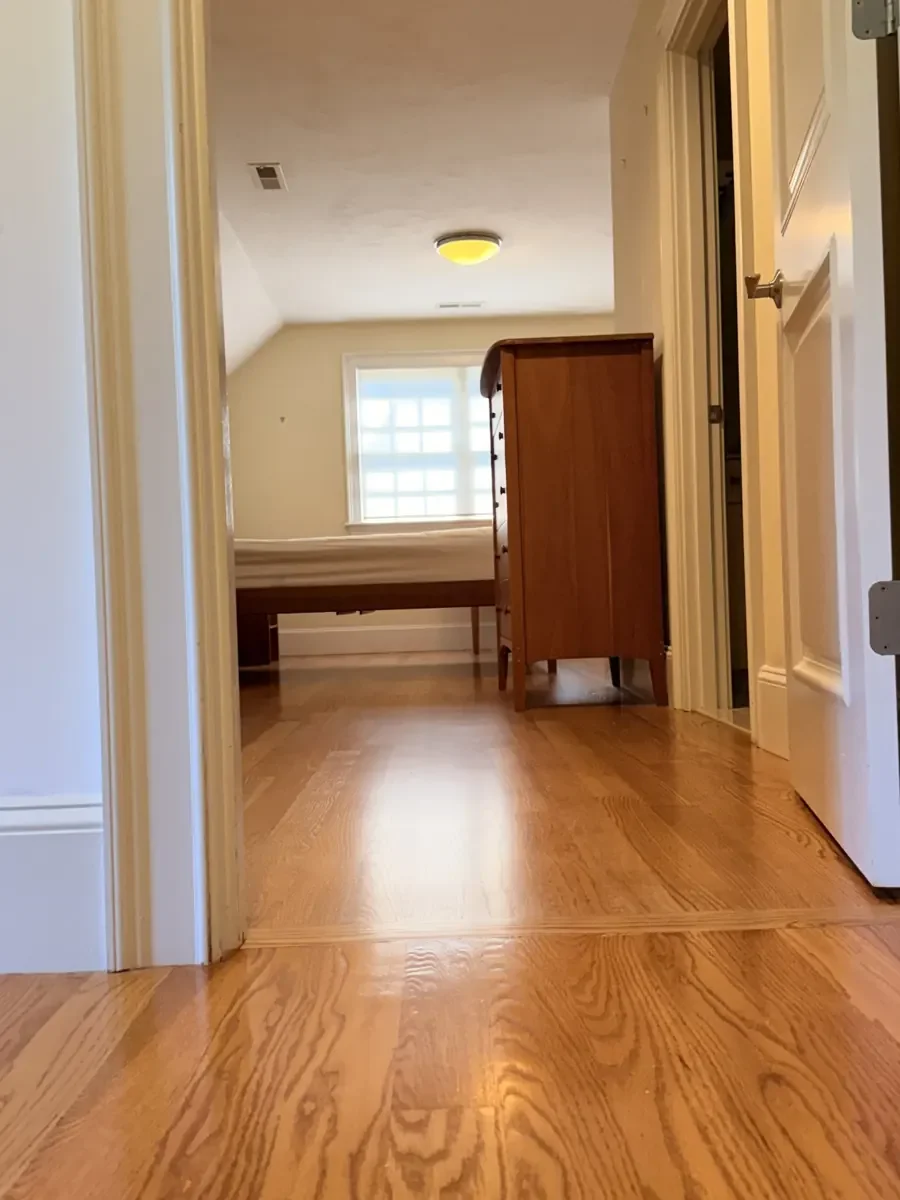 Completed red oak flooring in the Wellesley hallway and rear bedroom with furniture returned