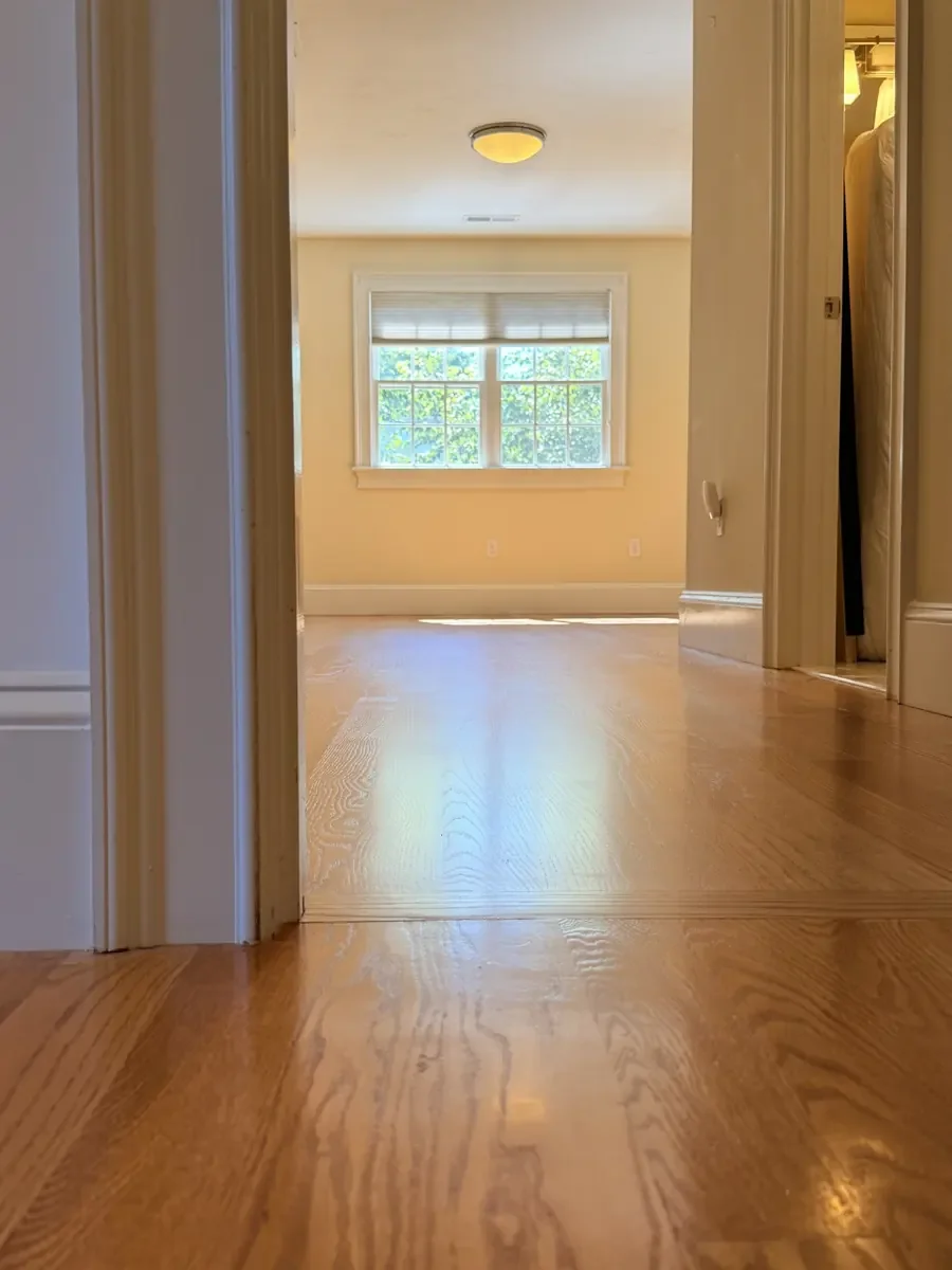Existing hardwood and bedroom connection after red oak installation and finishing