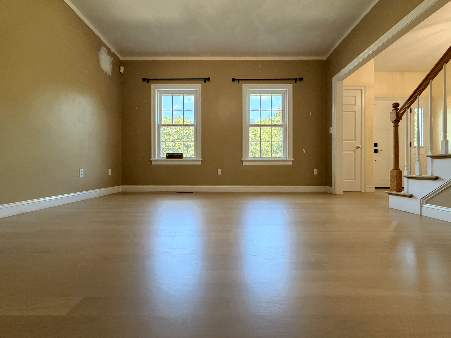 Refinished hardwood floor beside a staircase