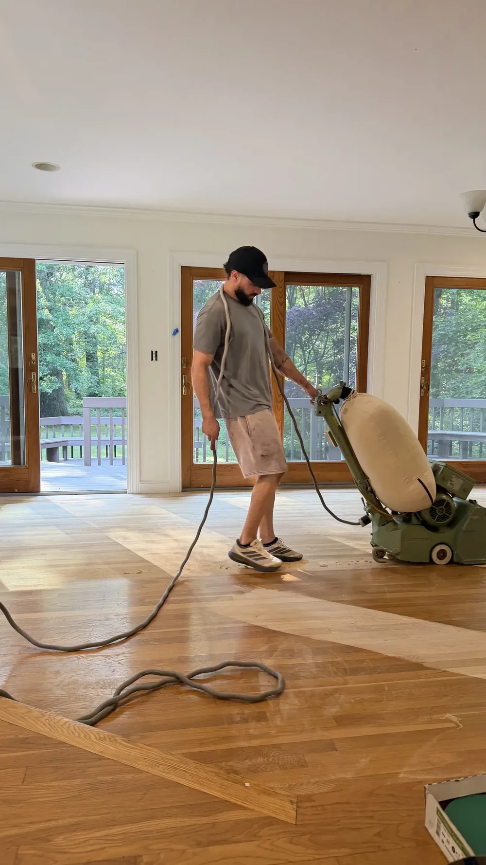 John, owner of Accolade Flooring, working with a hardwood floor sanding machine