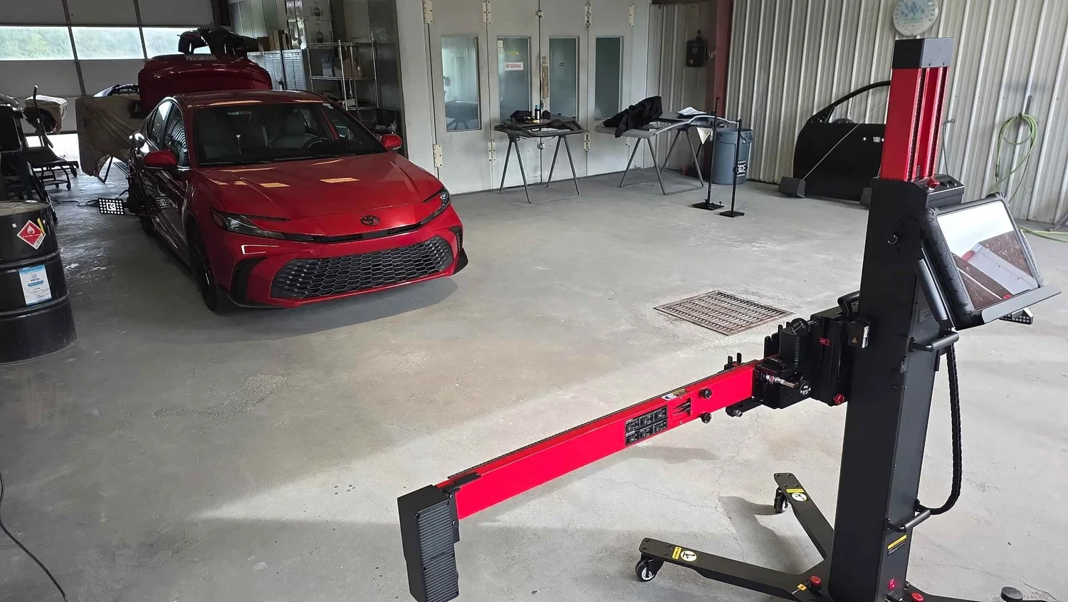 Red 2025 Toyota Camry Hybrid positioned with Autel ADAS calibration equipment