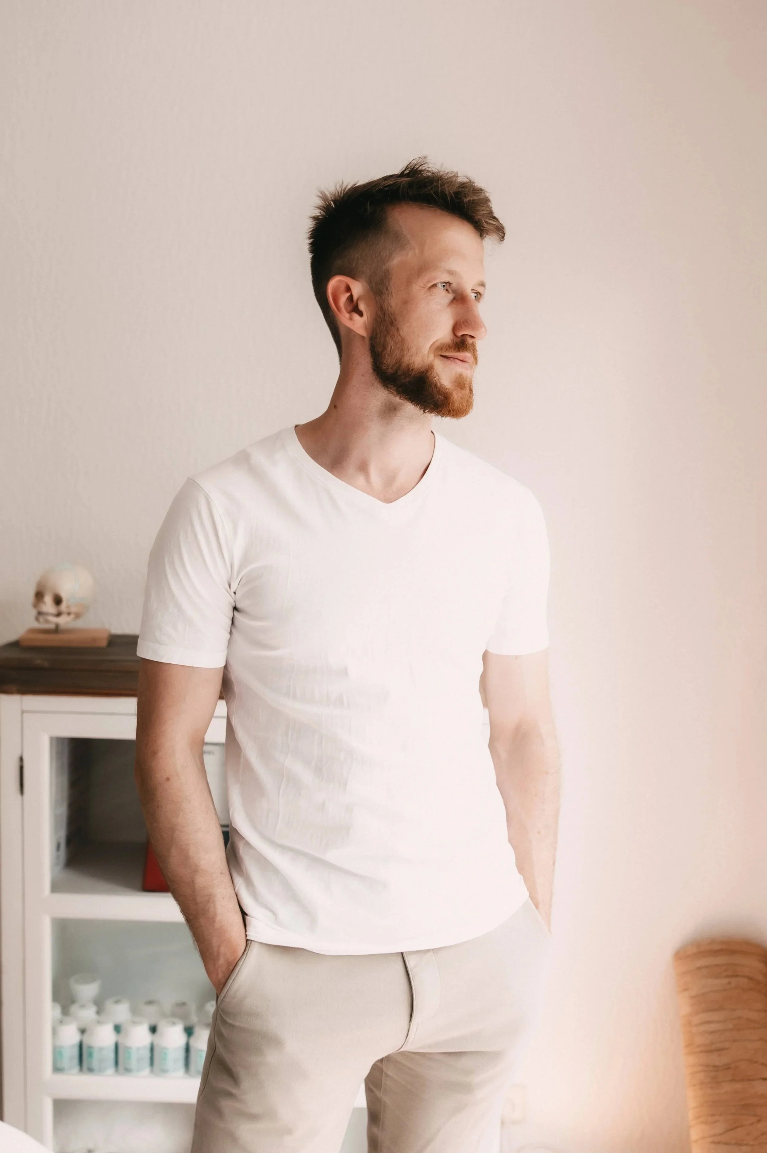 Osteopath Johannes Thies steht in seiner Praxis in Darmstadt und blickt ruhig zur Seite.