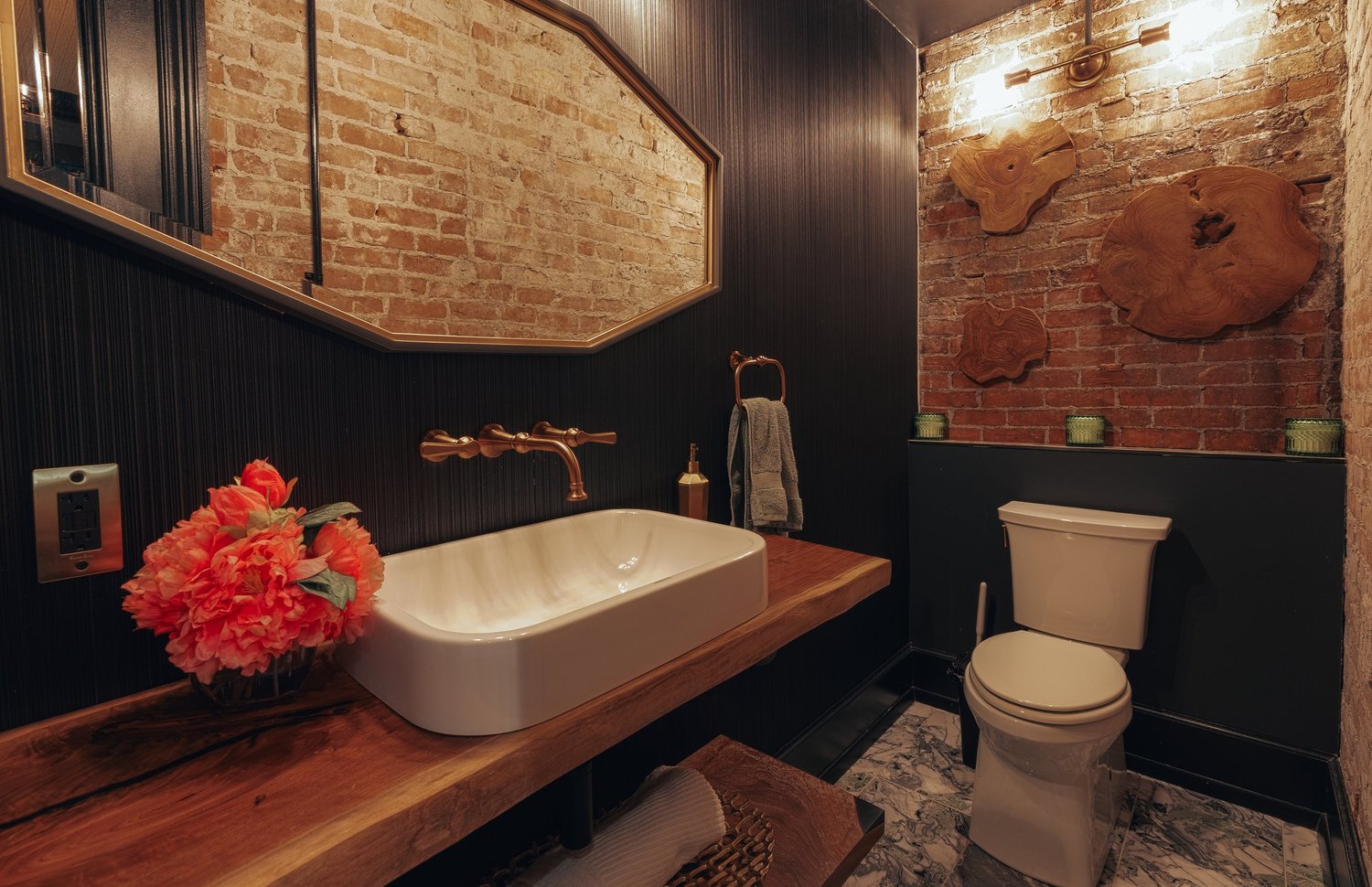 A powder room with a vessel sink and red flowers
