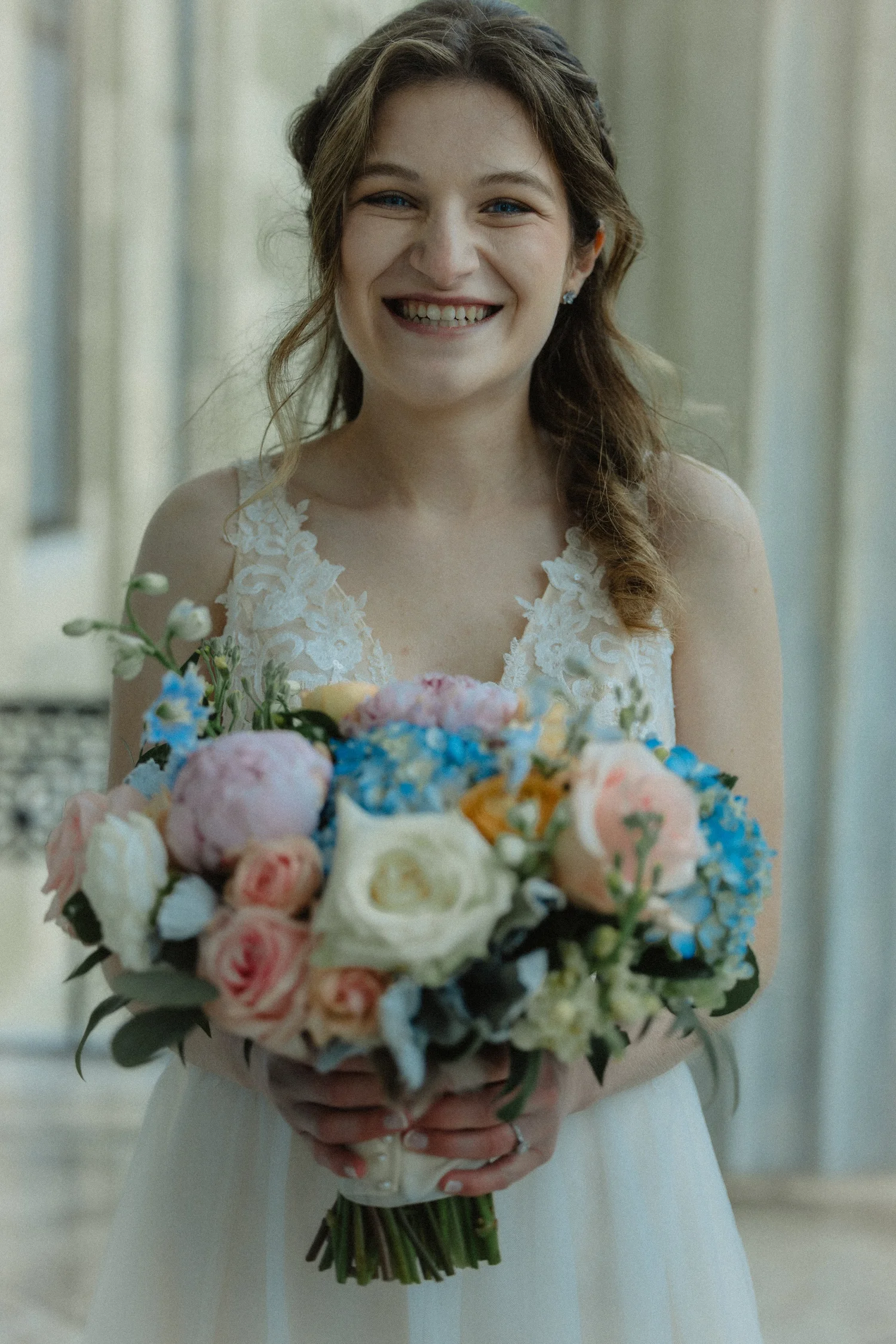 A bride smiling with her bouquet