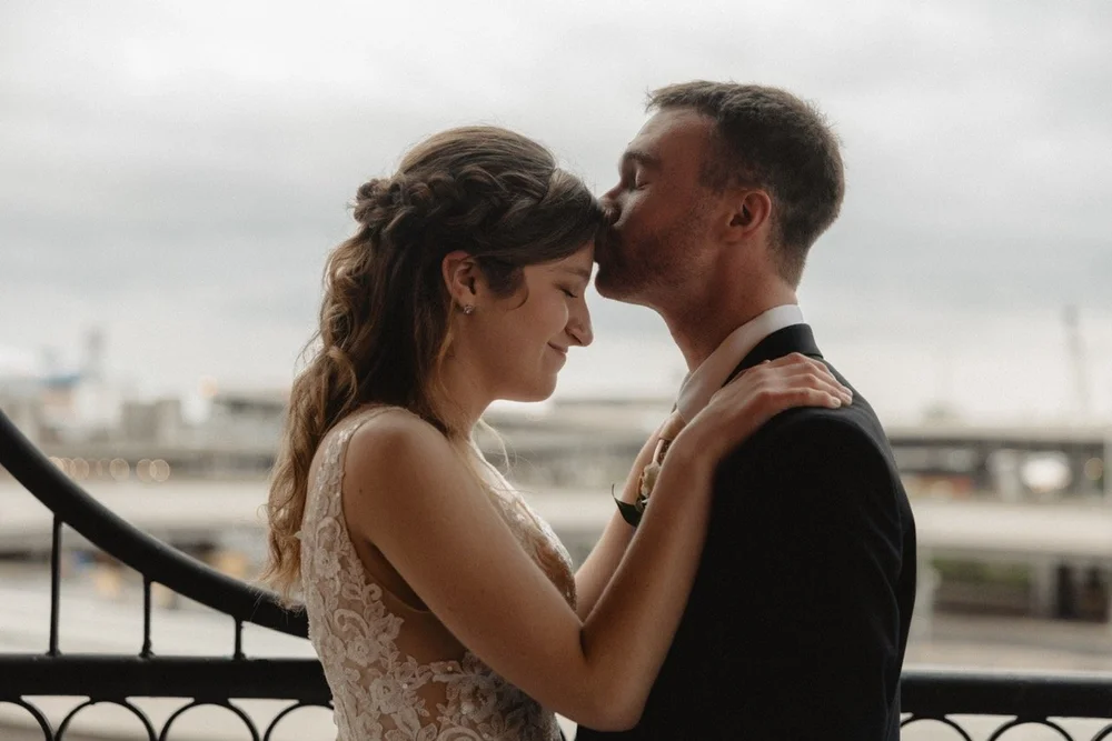 A groom kisses his bride's forehead