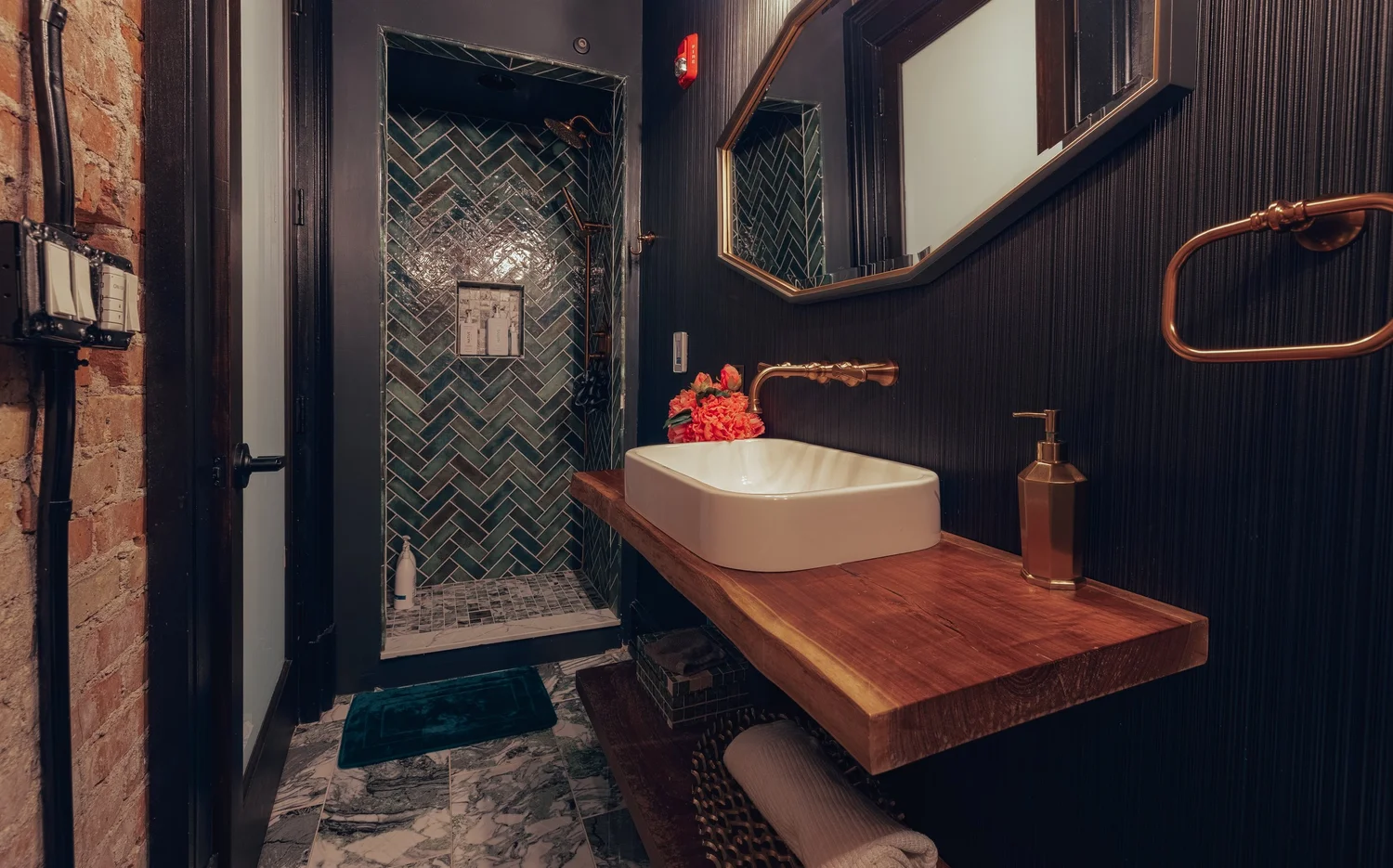 A washroom with a wood vanity and copper fixtures