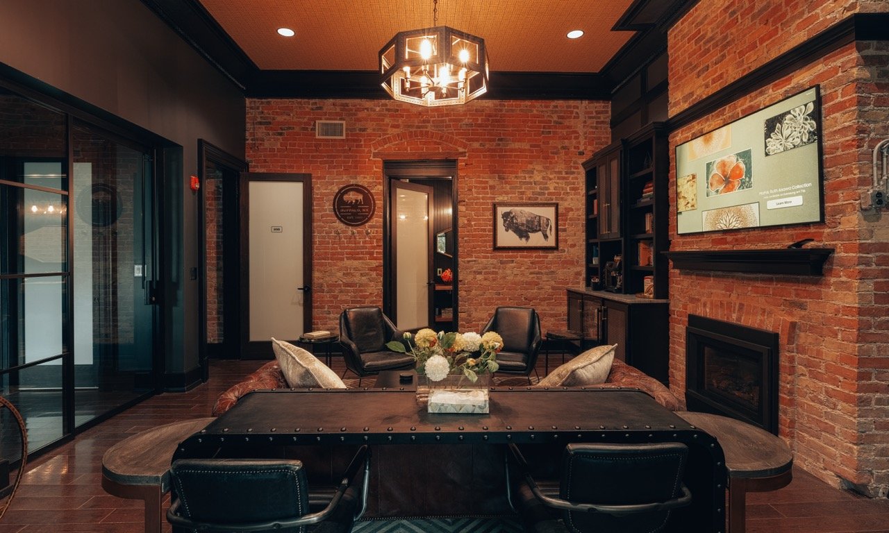 A lounge with a fireplace, leather chairs and a coffee table
