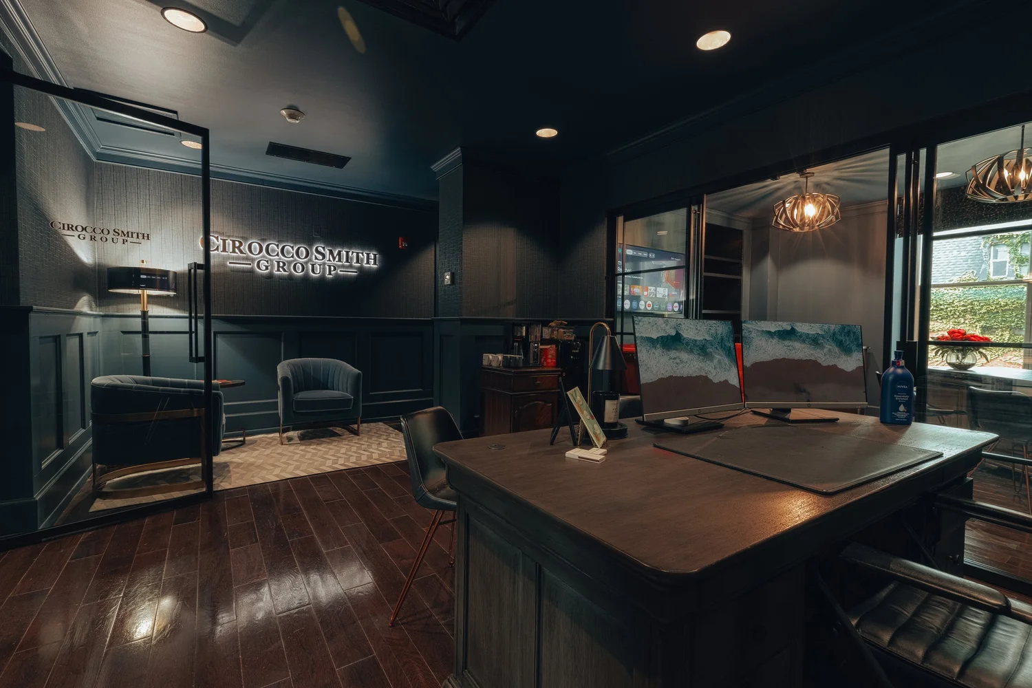A front desk with a wall sign and lounge chairs