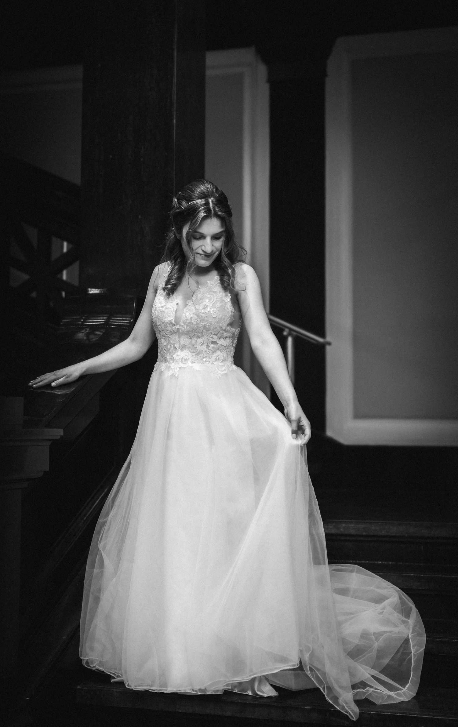 A bride in black and white holding her dress
