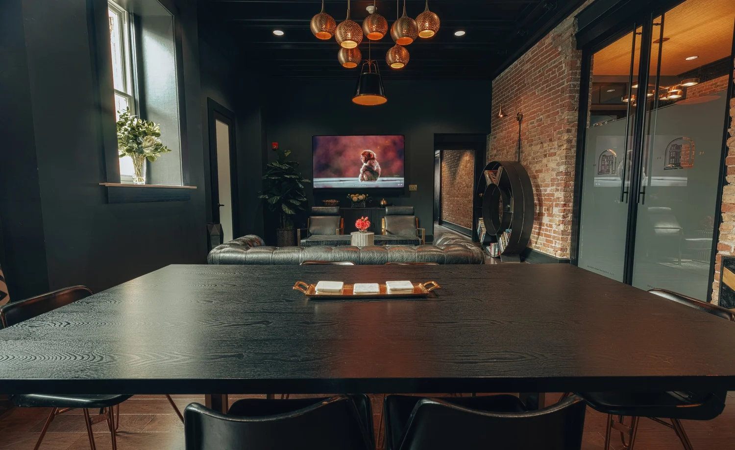 A dark conference table with a screen at the far wall