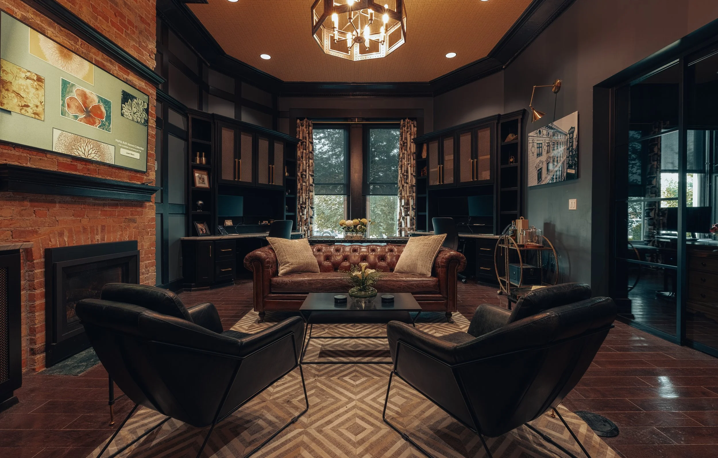 A lounge with leather sofas facing a fireplace