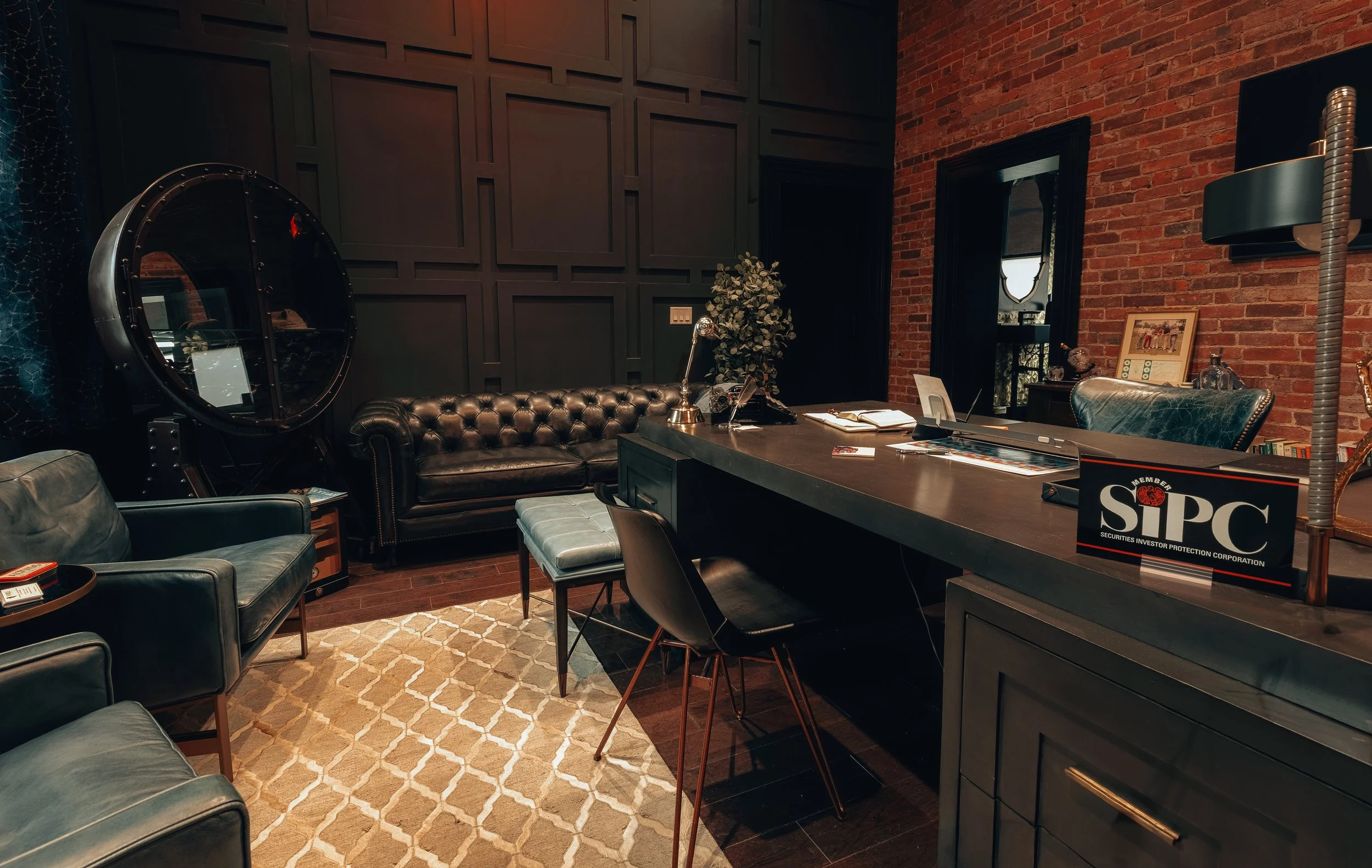 A reception desk with a leather sofa and pendant lights