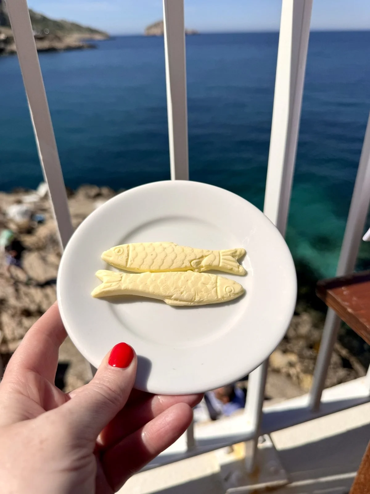 Sardine-shaped butter held over the sea