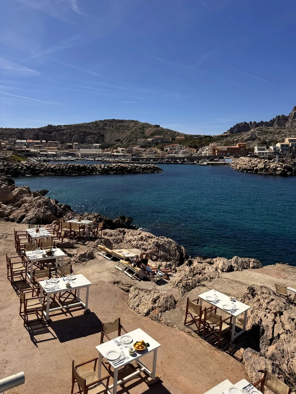 Restaurant terrace on the rocks above a blue bay