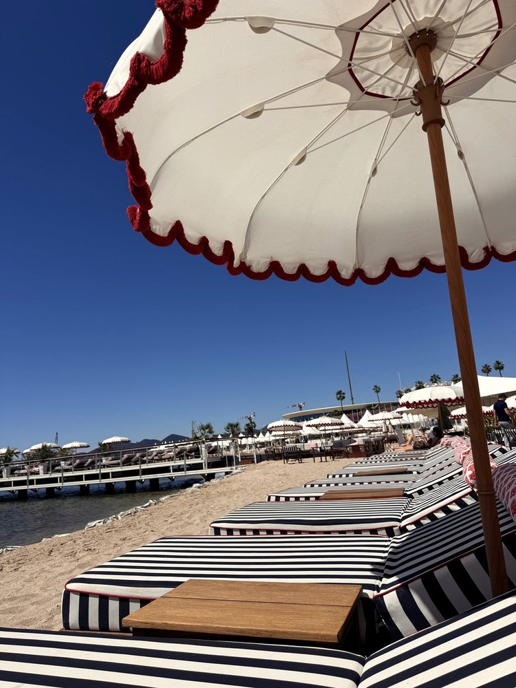 Striped loungers under a fringed umbrella in Cannes